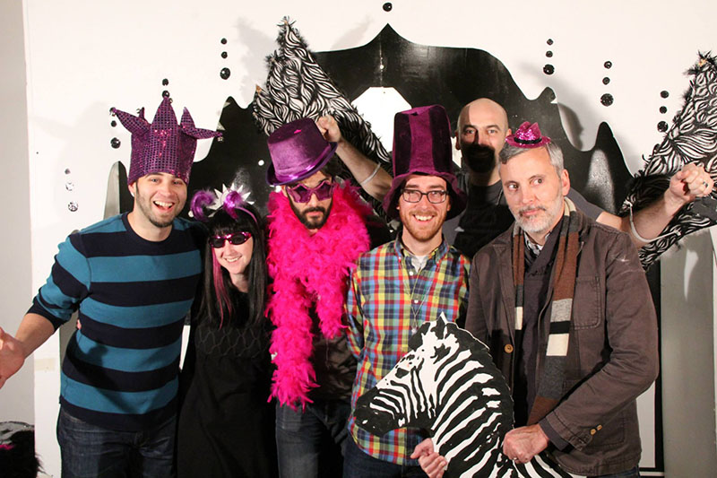 Artifact speakers wearing funny hats in a photobooth